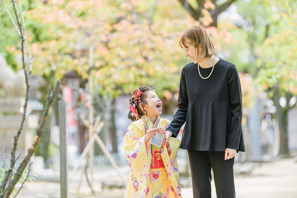 黄色の着物を着たお子さまとお母さまが笑い合う七五三撮影