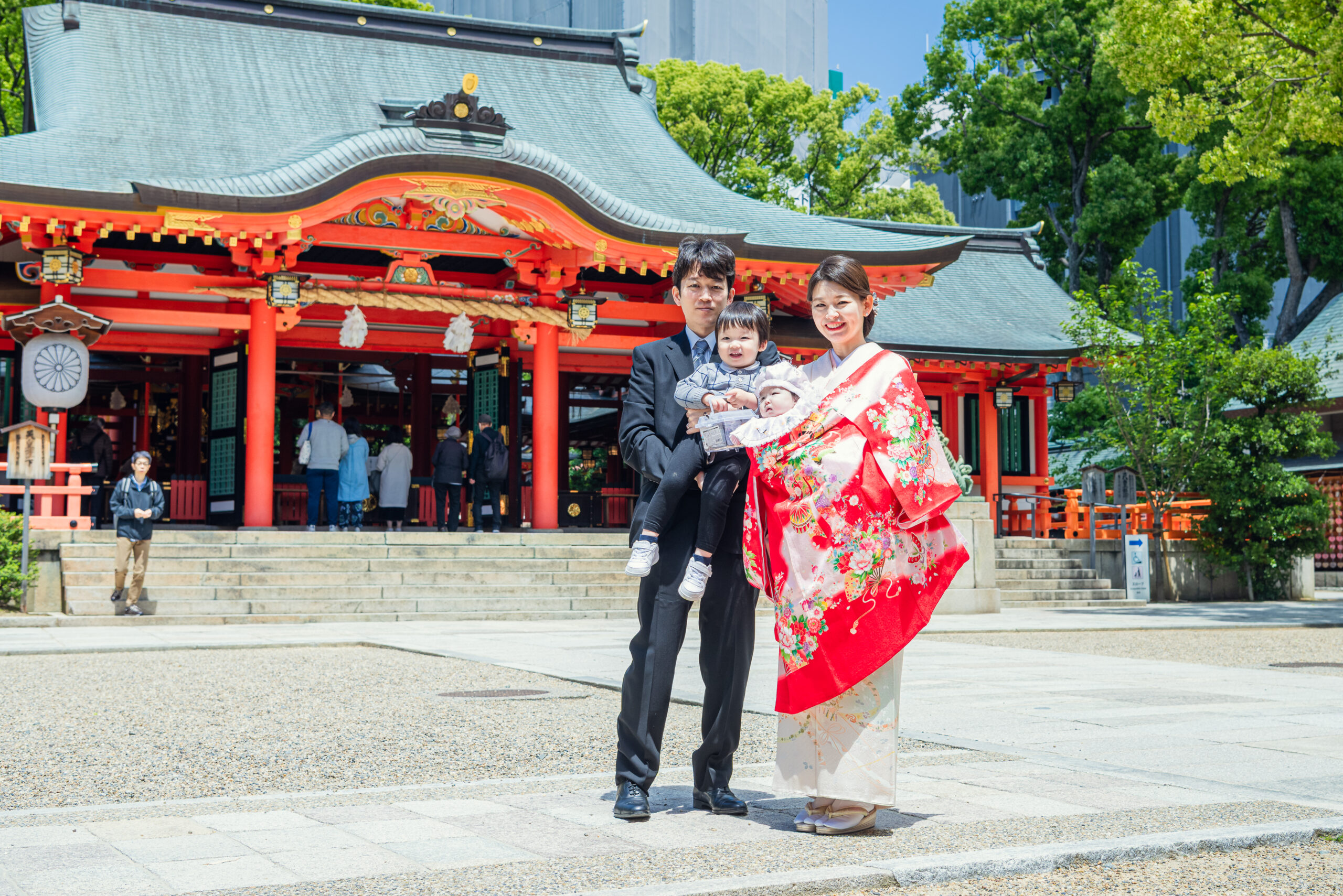 生田神社お宮参り|朱色のご本殿前でのご家族4人の集合写真【Lighthouse Photo】