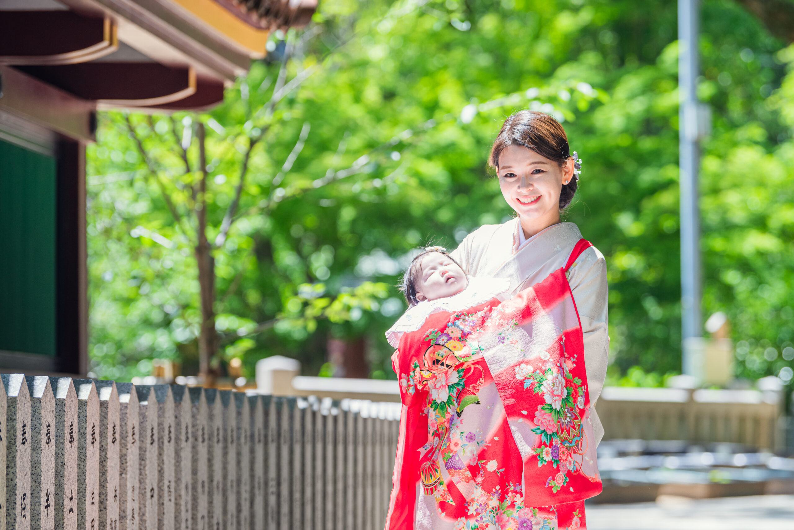 生田神社お宮参り|背景の緑がやさしくボケる、ママと主役のお子さまのふんわり2ショット【Lighthouse Photo】