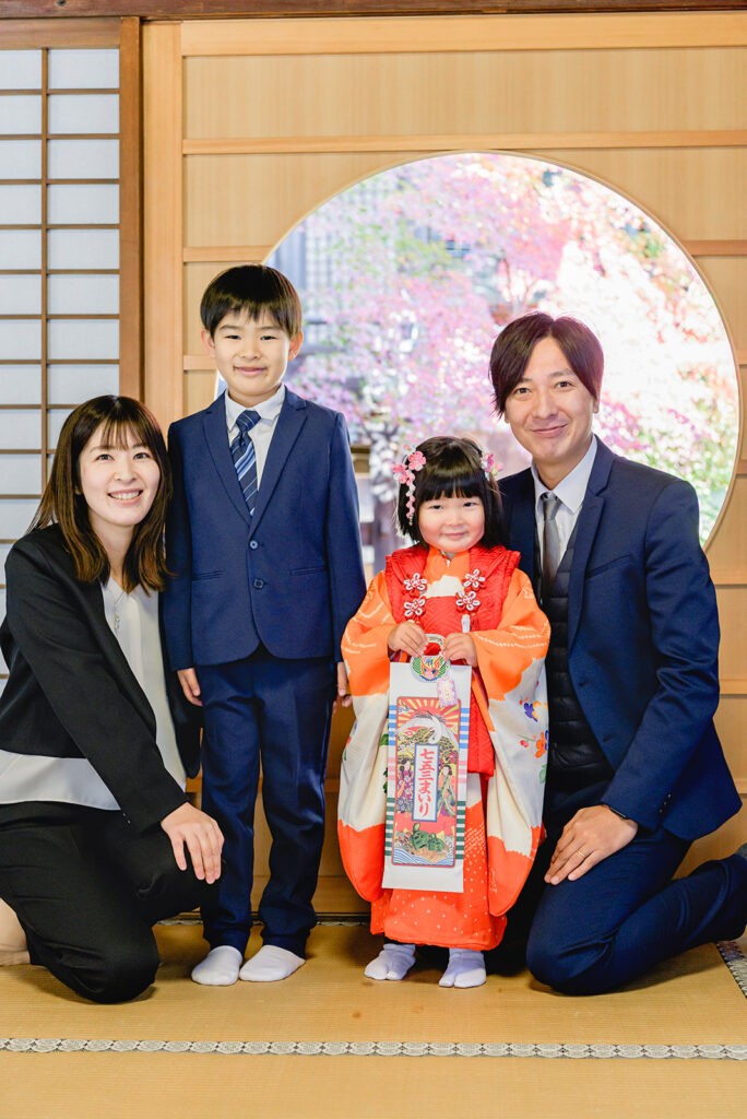 芦屋神社のご本殿の丸窓の前に並ぶご家族